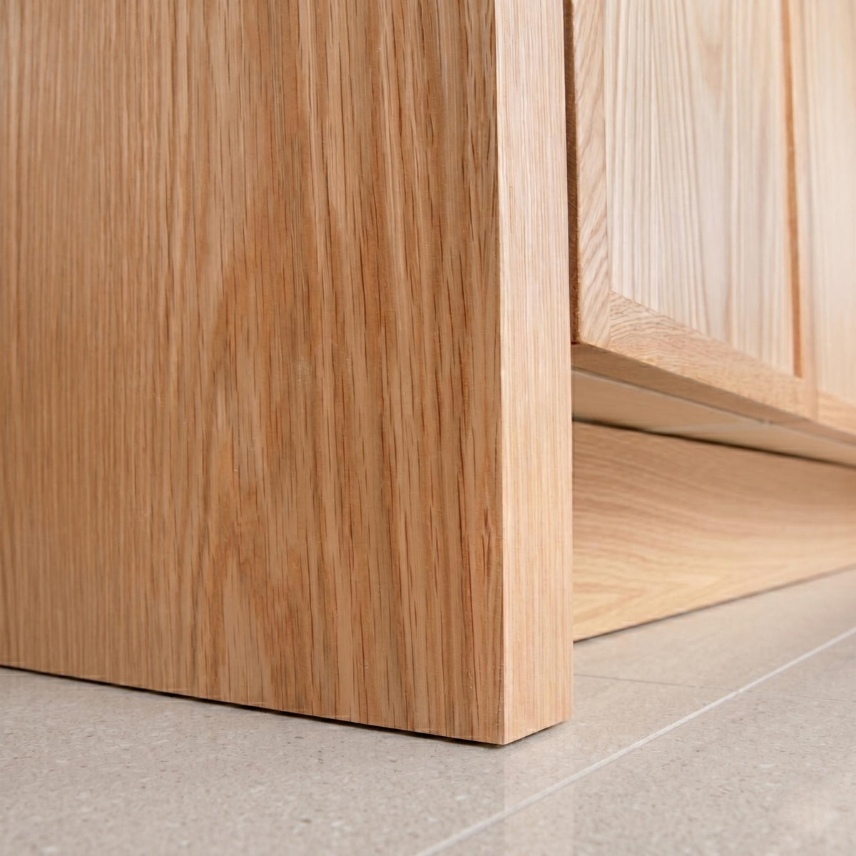 Close-up of a wooden cabinet corner on a light gray floor. Rosseau 36" White Oak Wood Bathroom Vanity