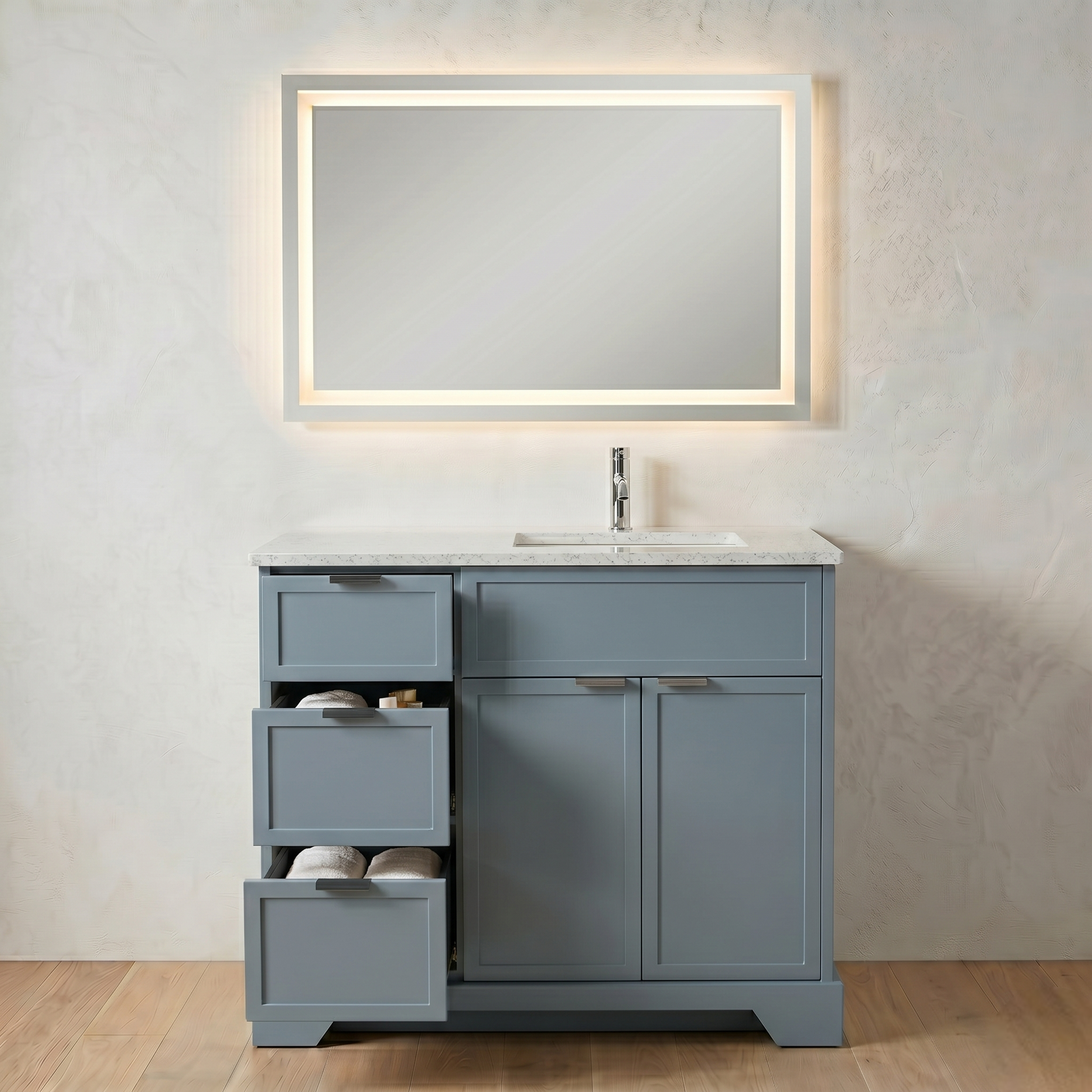 Gray bathroom vanity with a mirror and sink in a neutral-colored room.