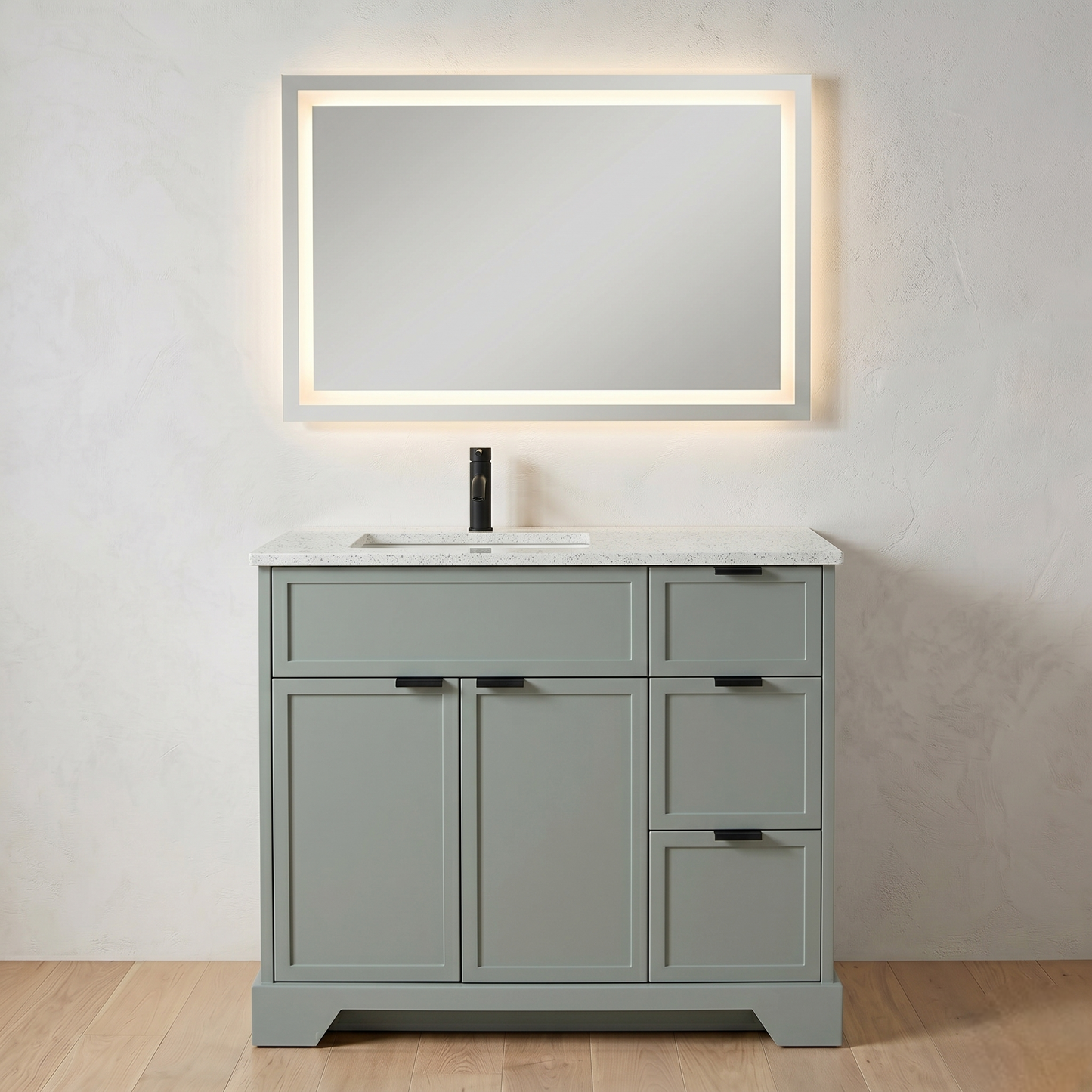 Gray bathroom vanity with white countertop and illuminated mirror on a light gray wall.