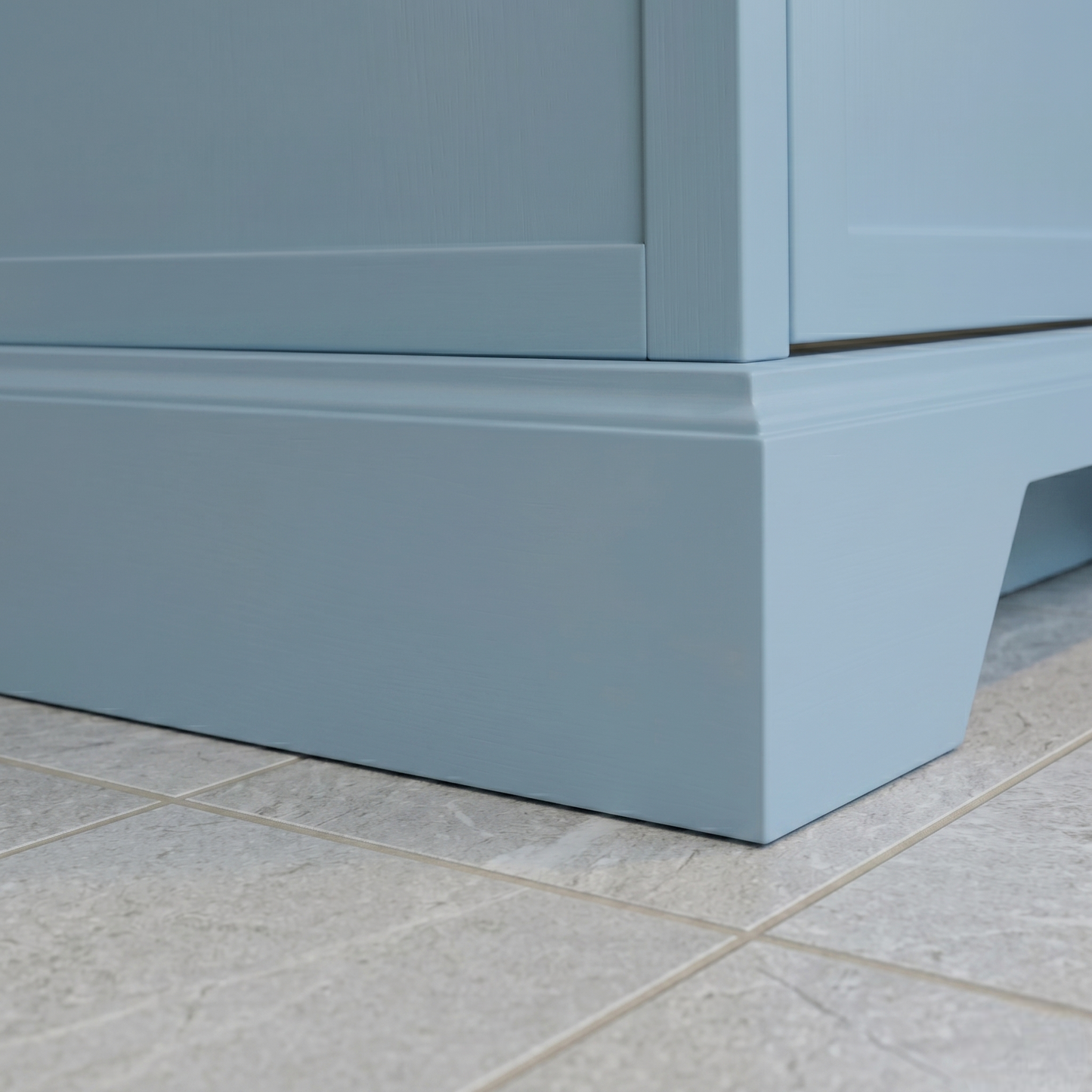 Close-up of a light blue cabinet base on a tiled floor