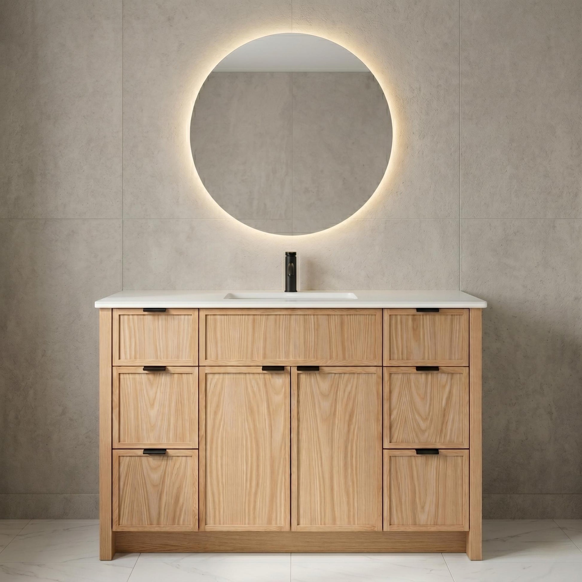 Bathroom vanity with wooden cabinets, round mirror, and white countertop against a beige tiled wall.