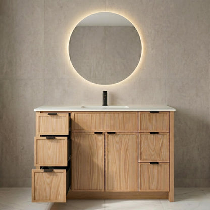 Wooden bathroom vanity with round mirror and light fixture on a tiled wall.